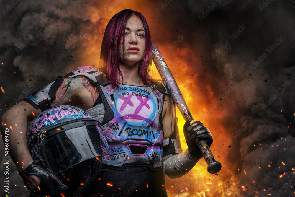 Obraz premium Strong woman with pink hairs holding baseball bat agains explosion