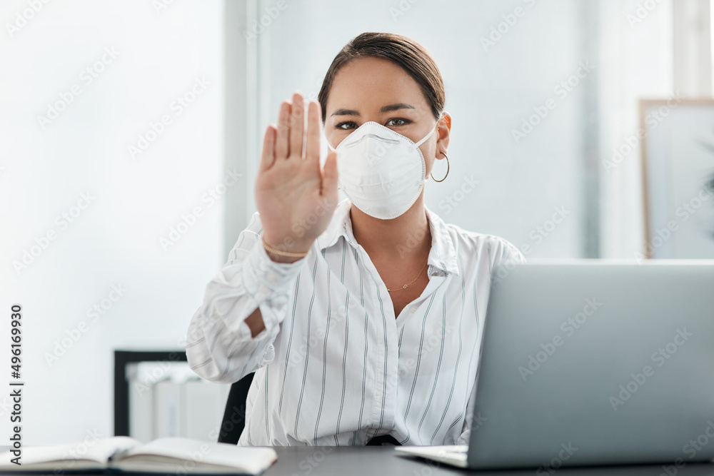 Keep your distance for your safety and mind. Shot of a masked young businesswoman gesturing to stay away while working at her desk in a modern office. Keep your distance for your safety and mind. Shot of a masked young businesswoman gesturing to stay away while working at her desk in a modern office.