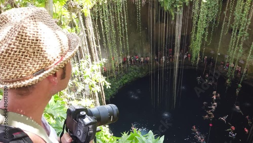Tourist man having great time at the Cenote Ik kil, which is underground natural pools and sacred Mayan ceremonial spaces. Today these cave-like swimming pools provide the most perfect way to cool off photo