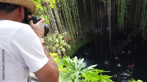 Tourist man having great time at the Cenote Ik kil, which is underground natural pools and sacred Mayan ceremonial spaces. Today these cave-like swimming pools provide the most perfect way to cool off photo