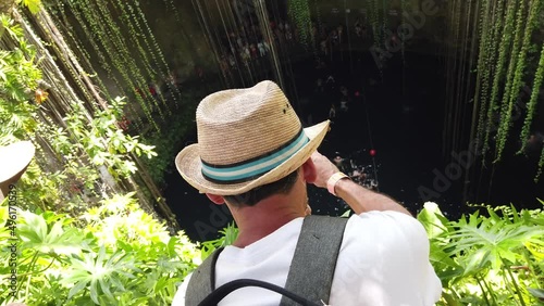 Tourist man having great time at the Cenote Ik kil, which is underground natural pools and sacred Mayan ceremonial spaces. Today these cave-like swimming pools provide the most perfect way to cool off photo