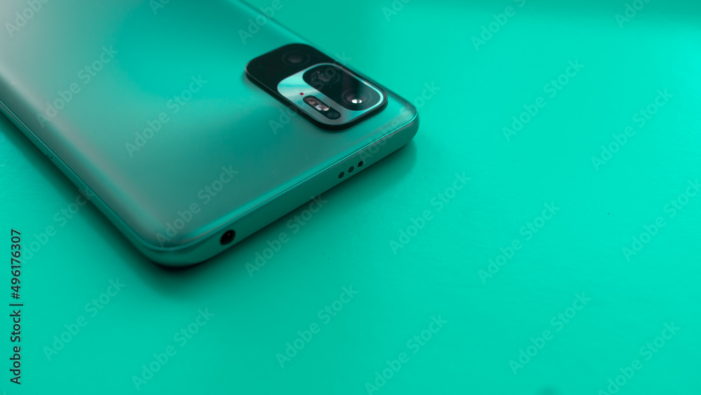 Turquoise smartphone with built-in camera close-up on a blue background