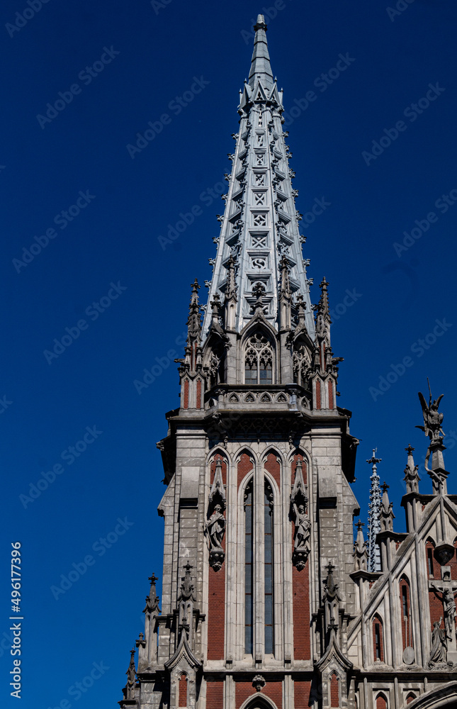 Peak of gothic style catholic church with blue sky in back