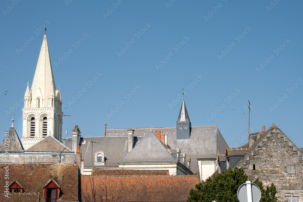 Obraz premium Tile and slate roofs and abbey church tower in Beaulieu les Loches on a sunny spring afternoon, Loire valley, France