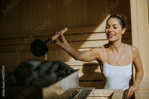 Young woman pouring water o...