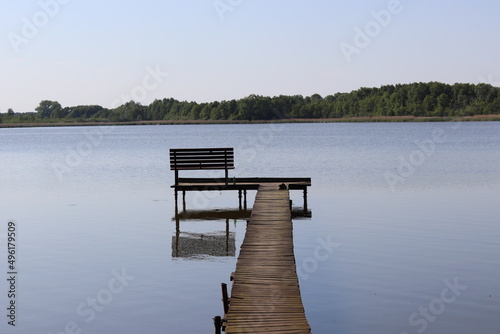 wooden pier with a bench by the lake