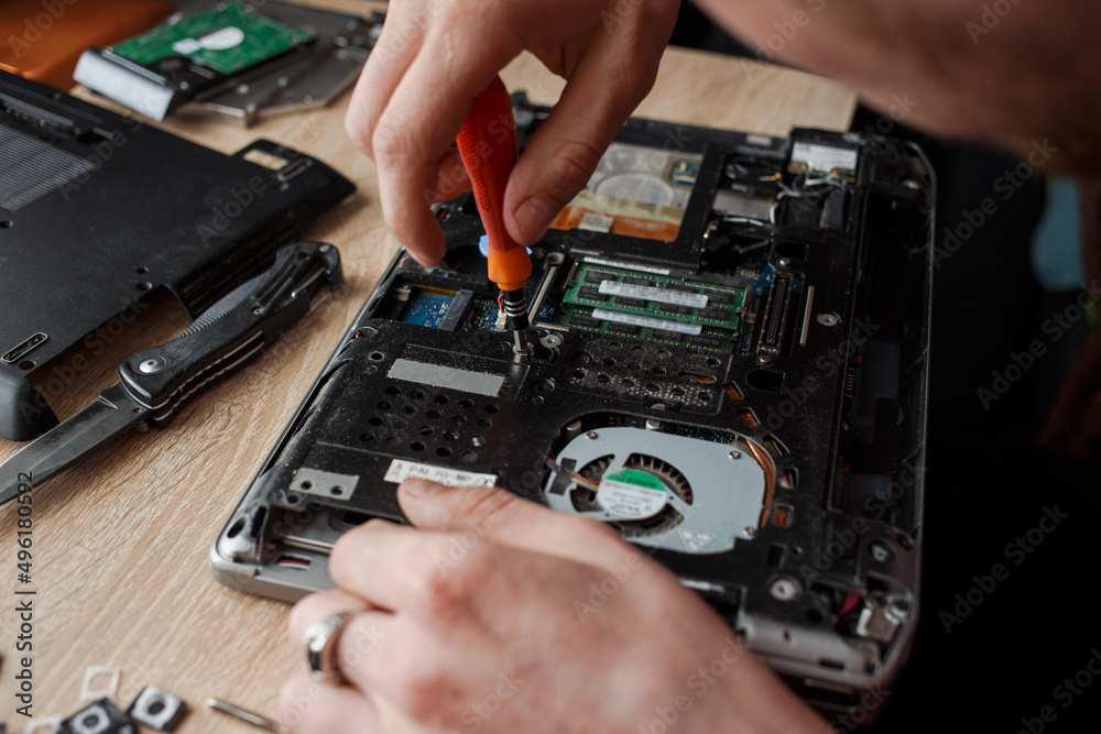 Man repairs laptop by himself, computer repair Man repairs laptop by himself, computer repair