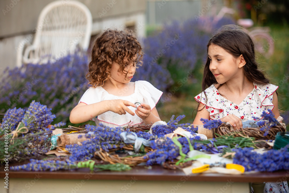 Fototapeta premium Girls make homemade lavender wreaths as a decor