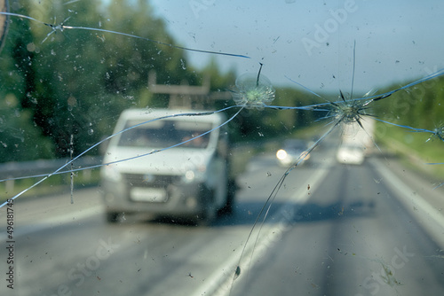 Highway through a broken windshield after encountering a truck with crushed stone. Challenging driving on Asian roads photo