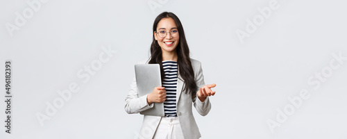 Business, finance and employment, female successful entrepreneurs concept. Smiling professional businesswoman, real estate broker showing clients good deal, carry laptop in hand photo