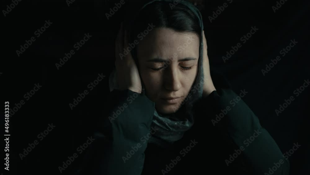 Scared woman hiding in a bomb shelter Scared woman hiding in a bomb shelter