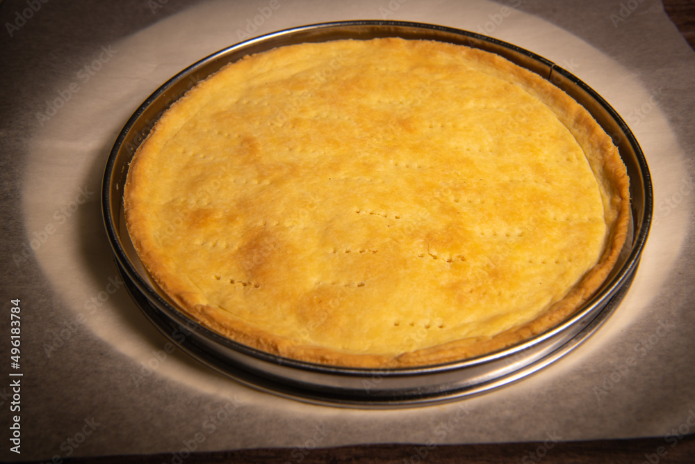 Metal fork makes holes in a raw pastry case in a metal baking tin Metal fork makes holes in a raw pastry case in a metal baking tin