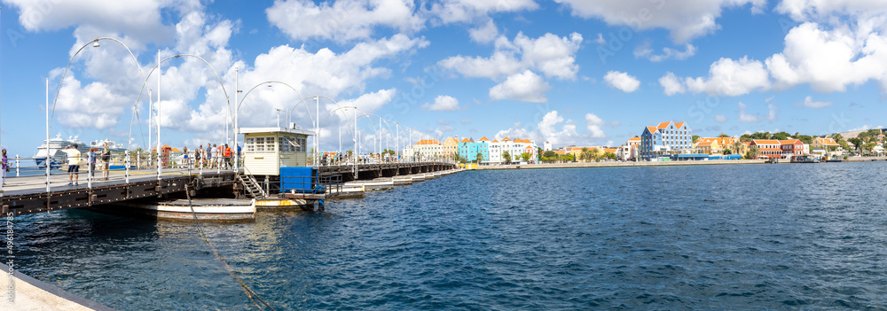 The famous Queen-Emma-Bridge with colorful buildings of the district Otrobanda in Willemstad, Curacao The famous Queen-Emma-Bridge with colorful buildings of the district Otrobanda in Willemstad, Curacao