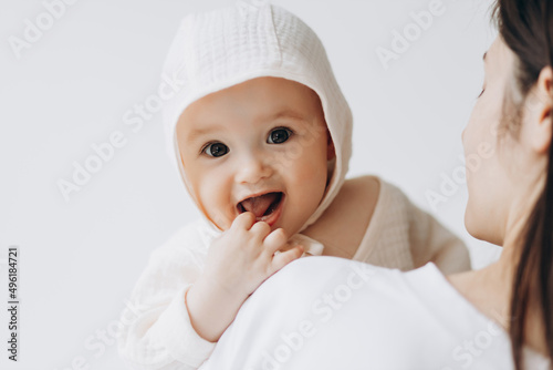 cute studio portrait of a little newborn girl posing for a photo in her mother's arms photo