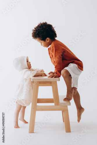 Fotografie Photos of children having fun and posing for a photo in summer linen clothes in a photo studio
