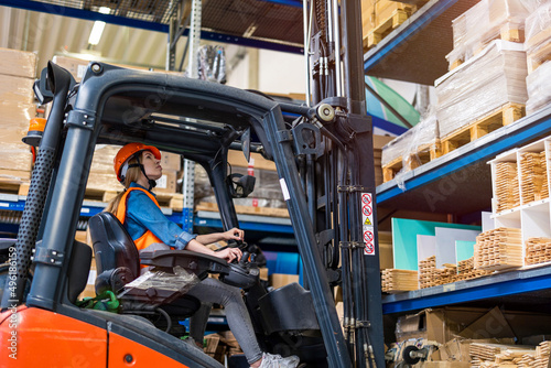 Young female forklift driver working in a warehouse
