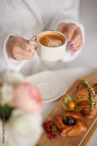 Woman hold cup of coffee,tasty bakery near. Good as mockup.