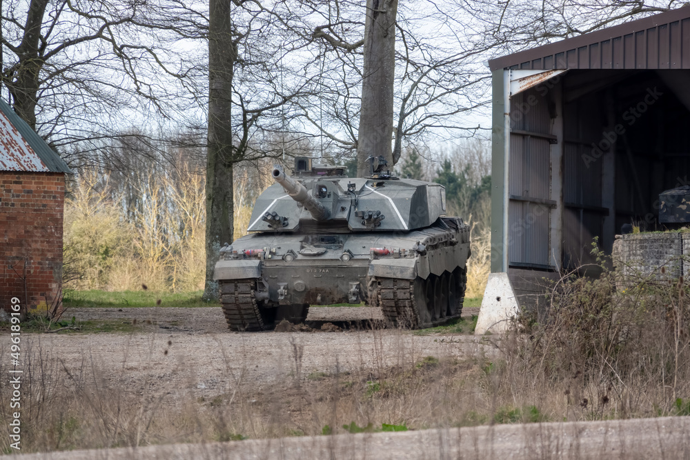 british army challenger 2 II FV4034 main battle tank stationary between empty buildings, awaiting deployment - obrazy, fototapety, plakaty 