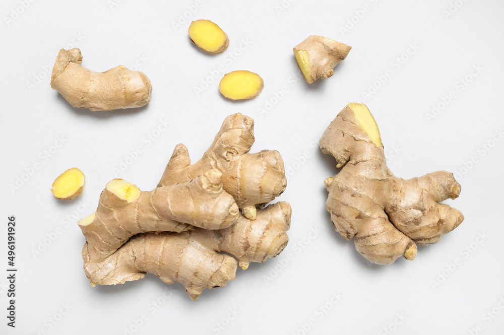 Fototapeta premium Fresh ginger root on light gray background top view flat lay. Spice for cooking, herbal tea with ginger to boost immunity. Natural organic ginger for health, medicine, protection against colds