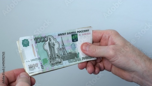 Men's hands count money, the currency is the Russian ruble. Concepts of finance and wealth. Banknotes of 1000 rubles in the hands of men. Investments, saving money.