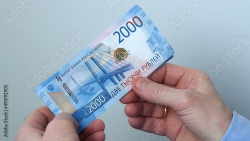 Men's hands count money, the currency is the Russian ruble. Concepts of finance and wealth. Banknotes of 2000 rubles in the hands of men. Investments, saving money.