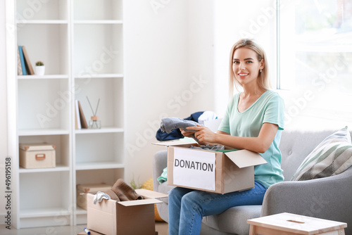 Young woman putting clothes...