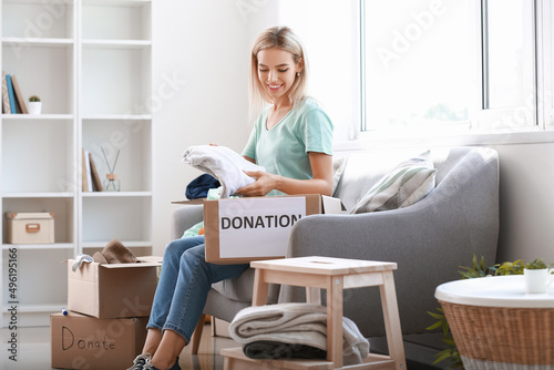 Young woman putting clothes...