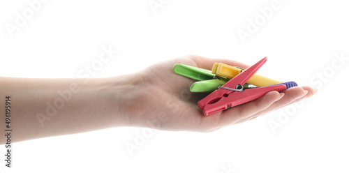 Female hand with plastic clothes pins on white background