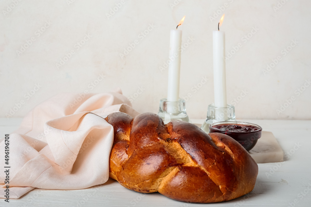 Traditional challah bread with glowing candles on white background. Shabbat Shalom - obrazy, fototapety, plakaty 