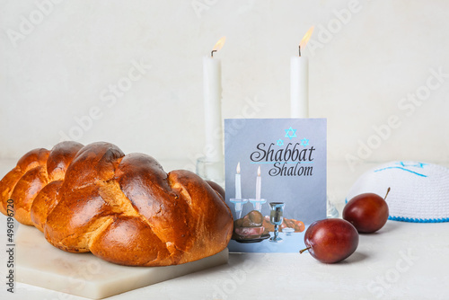 фотографія Traditional challah bread with greeting card and candles on white background