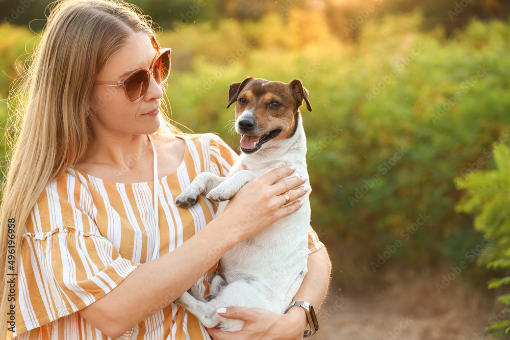 Young woman holding cute Jack Russel dog in park