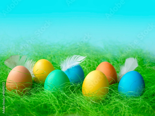 Happy Easter. A row of decorative multicolored Easter eggs on the green grass. Place for text