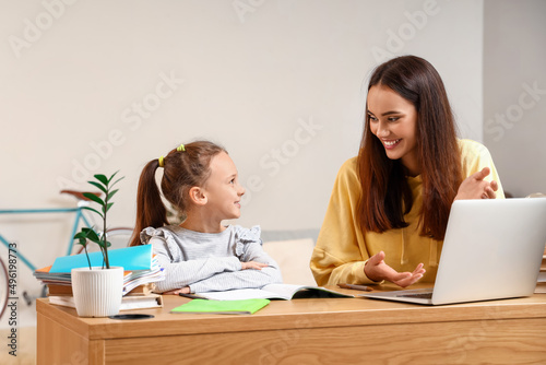 Cute girl studying with tut...
