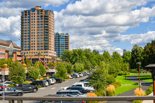 The public parking lot and park at McEuen Park in downtown Coeur d'Alene, Idaho, with the McEuen Towers and Coeur d'Alene skyline in view during summer. photo