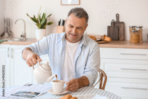 Senior man pouring tea into...