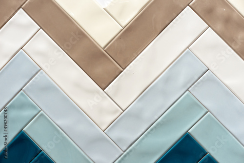 Glossy ceramic tiles in the shape of a herringbone.