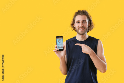Sporty man holding phone wi...