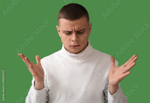Worried young man on green ...
