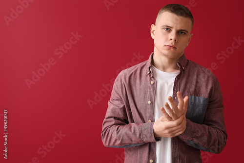 Worried young man on red ba...