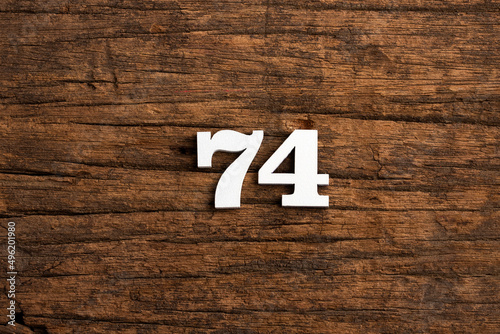 Number 74 - piece on rustic wood background