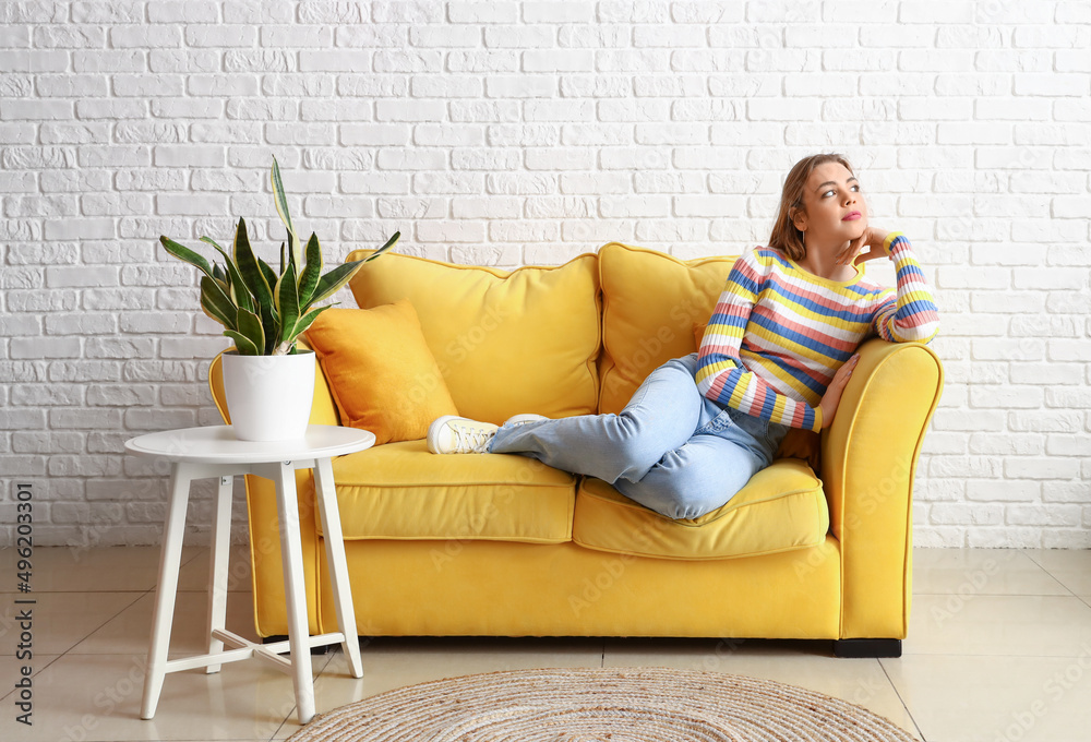 Obraz premium Pretty young woman relaxing on sofa at home