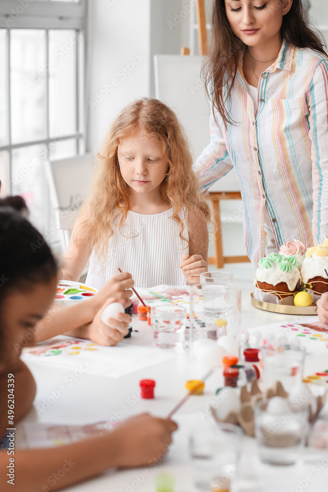 Cute children painting during master-class in art on Easter eve Cute children painting during master-class in art on Easter eve