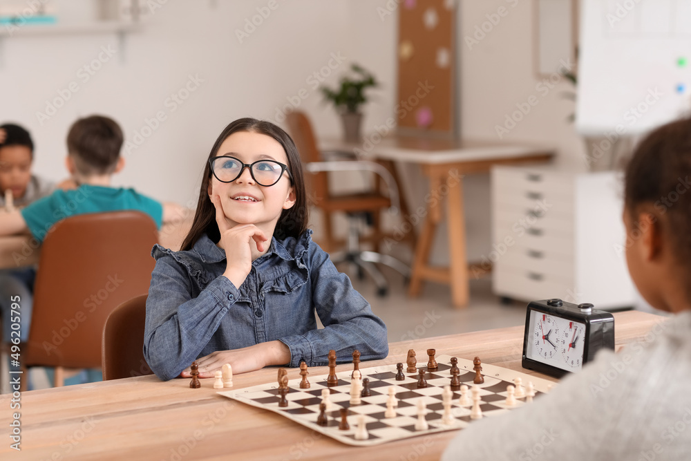 Fototapeta premium Little children playing chess during tournament in club