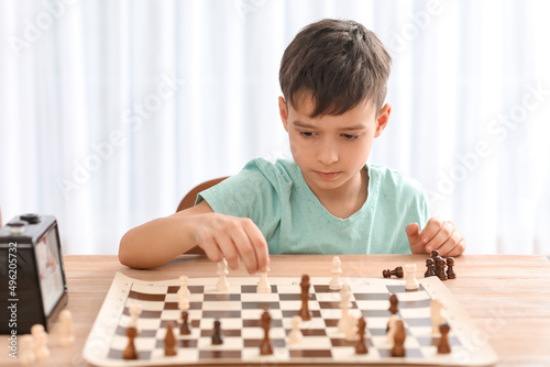 Little boy playing chess du...