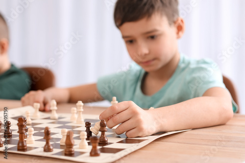 Little boy playing chess du...