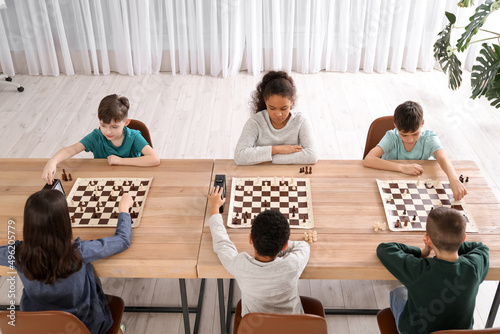 Konstfotografi Little children playing chess during tournament in club
