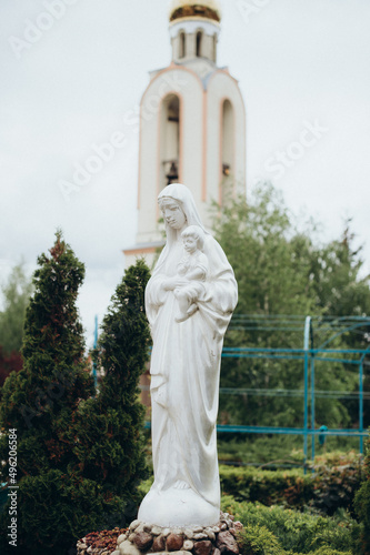 statue of the mother of God on the background of the Ukrainian Orthodox Church