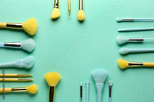 Set of makeup brushes on color background with space for text