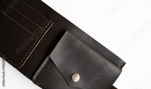 Top view of open brown empty man's black handmade genuine leather wallet with pockets for banknotes, credit cards and monets isolated on white background. Selective focus, copy space, Close up.