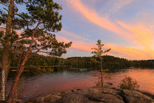 Brilliant sunset over northern Minnesota fishing lake fills sky with colorful clouds and subtle golden hour hues photo